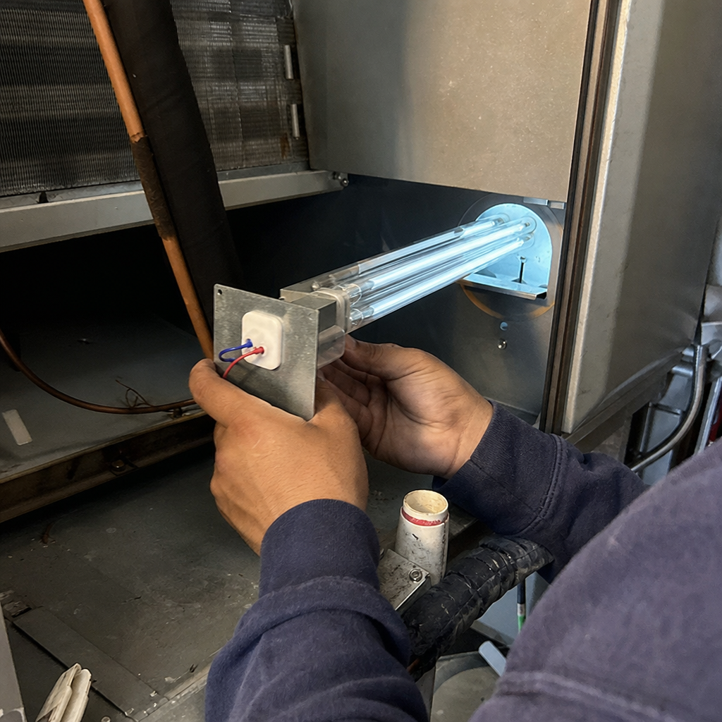 HVAC technician installing a UV germicidal lamp for air duct sanitizing. in Hackensack, NJ